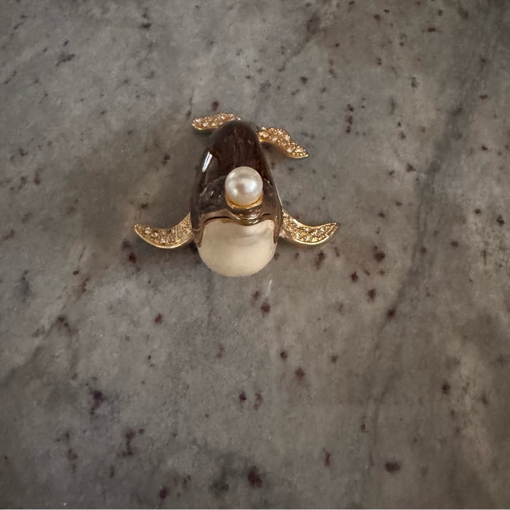 a brown seal, trimmed gold with a pearl nose, clear gems for fins, feet trinket
